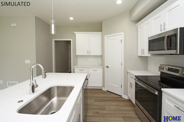 kitchen with dark hardwood / wood-style flooring, sink, white cabinets, and stainless steel appliances