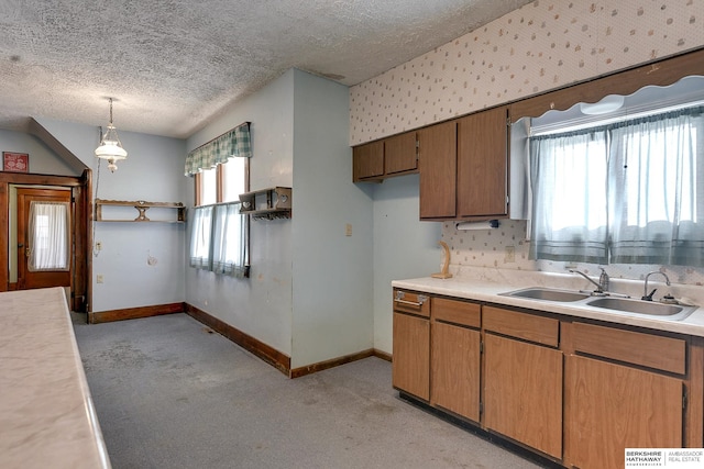 kitchen featuring a textured ceiling, decorative light fixtures, plenty of natural light, and sink