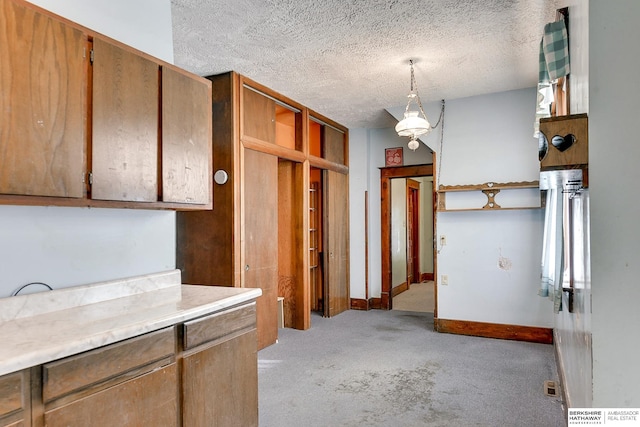 kitchen with pendant lighting, a textured ceiling, and light colored carpet