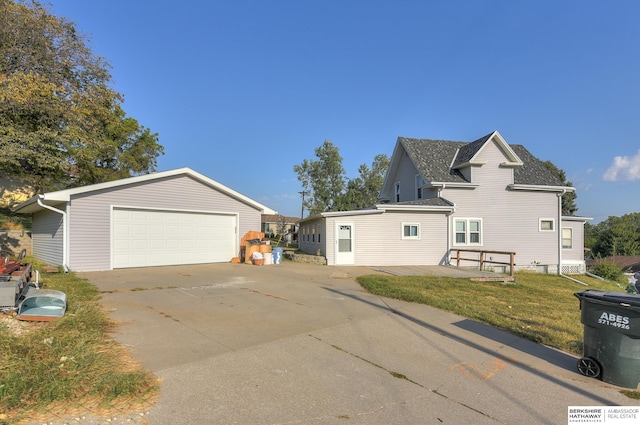 view of front facade featuring a front yard, an outdoor structure, and a garage