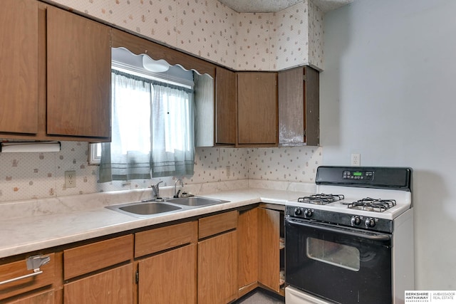 kitchen featuring white range with gas cooktop and sink