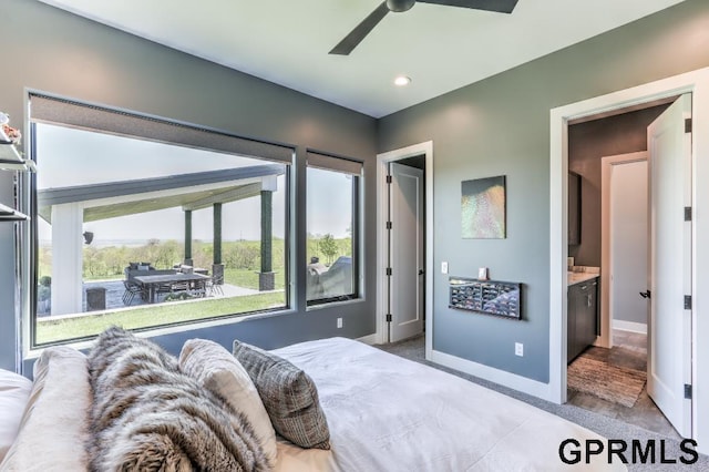 carpeted bedroom with ensuite bath and ceiling fan