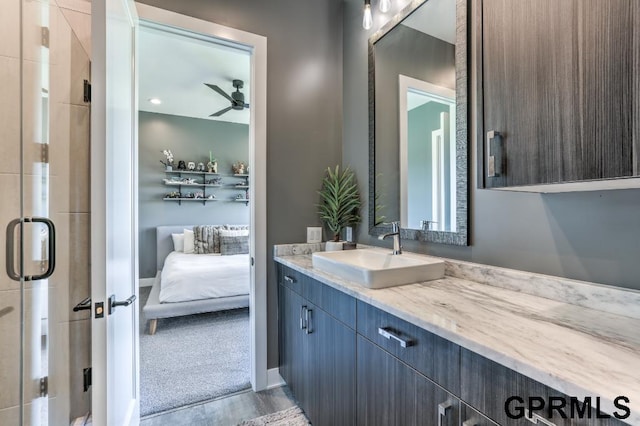 bathroom featuring ceiling fan, vanity, a shower with shower door, and hardwood / wood-style flooring