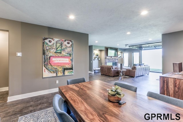 dining space featuring a textured ceiling and a fireplace