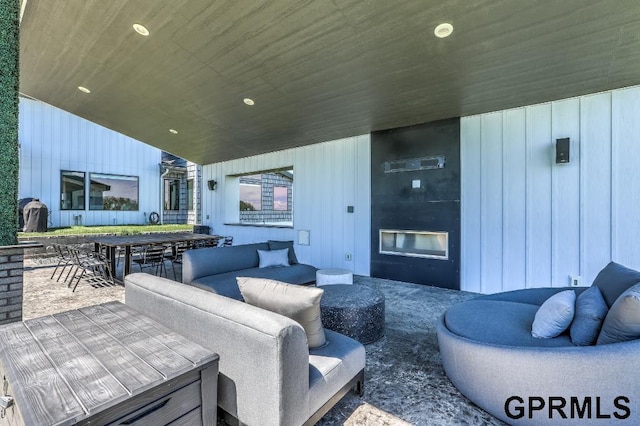 exterior space featuring wood ceiling, a fireplace, wood walls, and vaulted ceiling