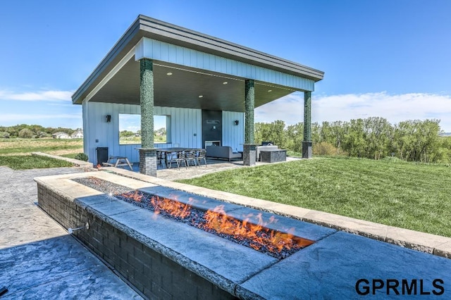 rear view of house with central AC unit, a yard, a patio, and an outdoor fire pit