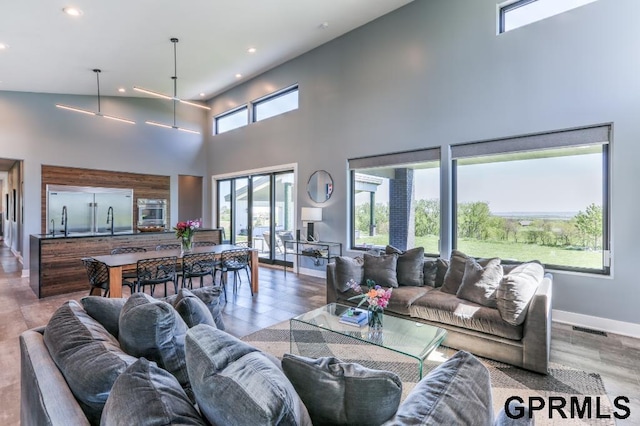 living room featuring wood-type flooring, a wealth of natural light, and high vaulted ceiling