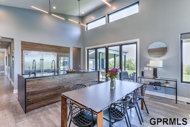 dining area with a towering ceiling and plenty of natural light