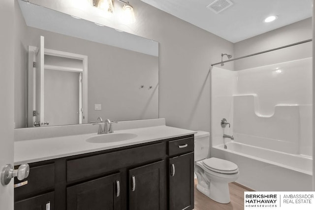 full bathroom with toilet, vanity, hardwood / wood-style floors, and shower / bathtub combination