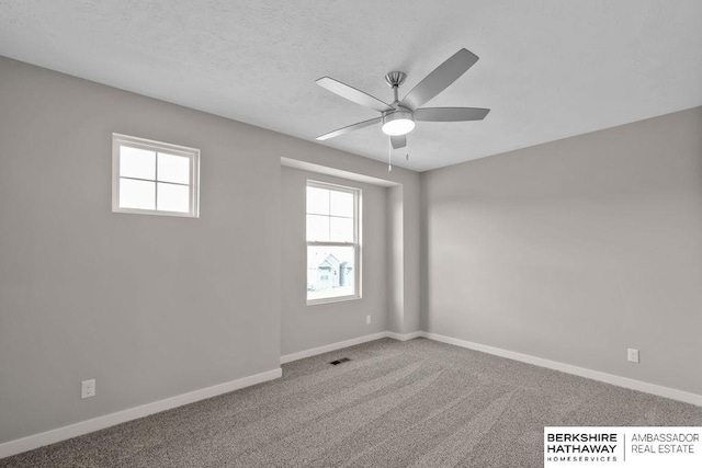 carpeted spare room featuring ceiling fan