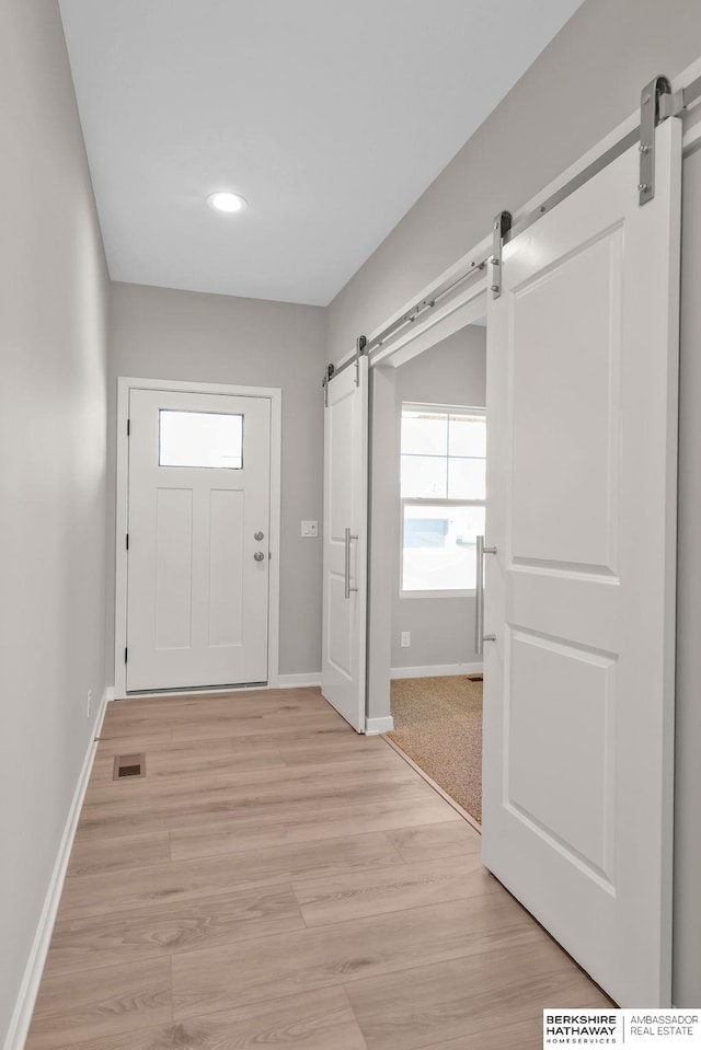 doorway to outside featuring light wood-type flooring and a barn door