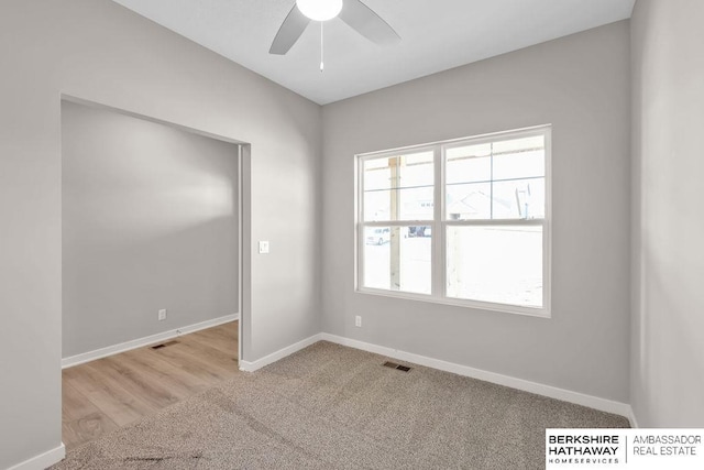 empty room featuring ceiling fan and light carpet