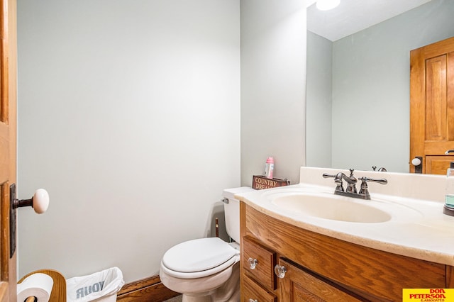 bathroom with hardwood / wood-style flooring, vanity, and toilet