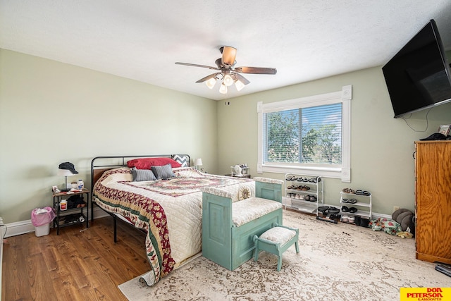 bedroom featuring a textured ceiling, wood-type flooring, and ceiling fan