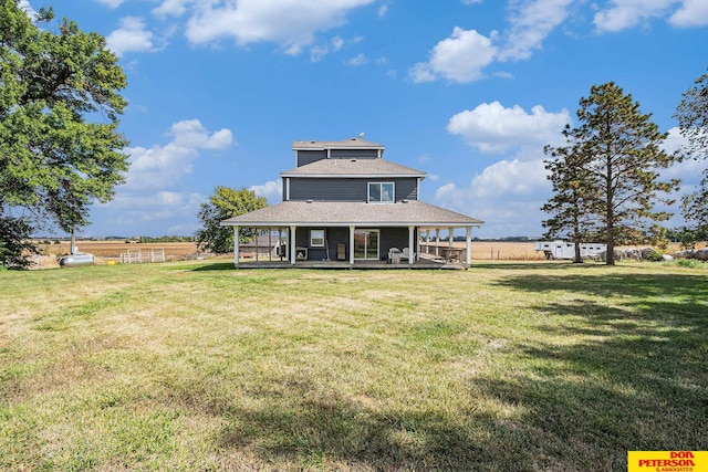 rear view of property with a lawn, a porch, and a rural view