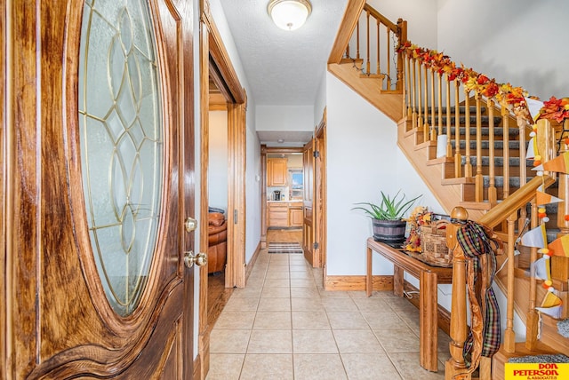 entryway featuring a textured ceiling and light tile patterned flooring