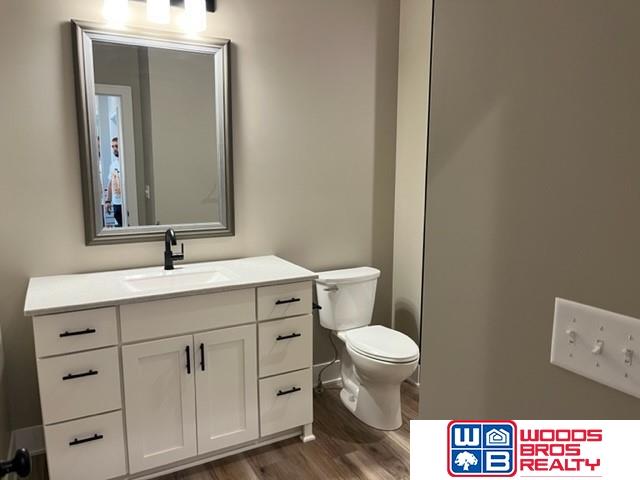 bathroom featuring vanity, toilet, and hardwood / wood-style flooring