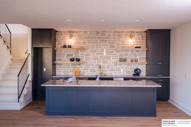 kitchen with a kitchen island with sink and light hardwood / wood-style flooring