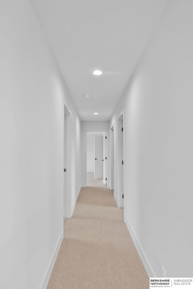 hall with light colored carpet