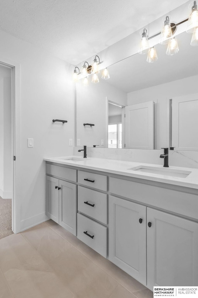 bathroom featuring tile patterned floors, vanity, and a textured ceiling