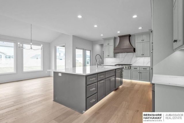 kitchen featuring sink, stainless steel gas cooktop, tasteful backsplash, gray cabinets, and custom exhaust hood