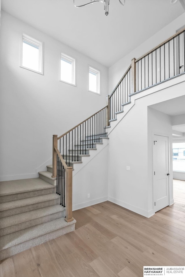 stairway with wood-type flooring and plenty of natural light