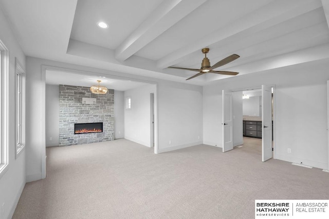 unfurnished living room with light carpet, beam ceiling, ceiling fan with notable chandelier, and a fireplace