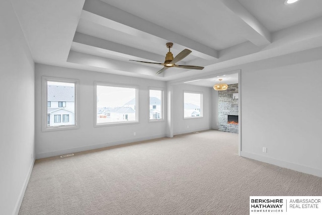 unfurnished living room with ceiling fan, a stone fireplace, and light carpet