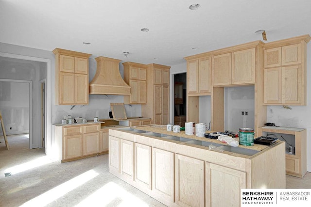 kitchen with a center island, light brown cabinetry, and wall chimney exhaust hood