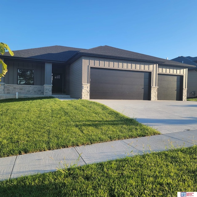 prairie-style house with a garage and a front lawn