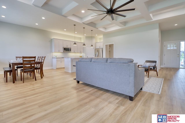 living room featuring beamed ceiling, light hardwood / wood-style floors, ceiling fan, and coffered ceiling