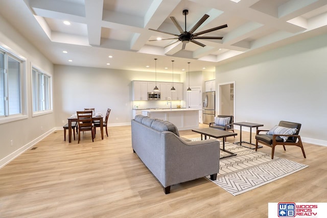 living room with coffered ceiling, ceiling fan, and light hardwood / wood-style flooring