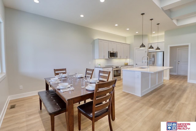 dining area featuring sink and light hardwood / wood-style floors