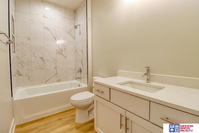 full bathroom featuring vanity, tiled shower / bath combo, toilet, and hardwood / wood-style flooring