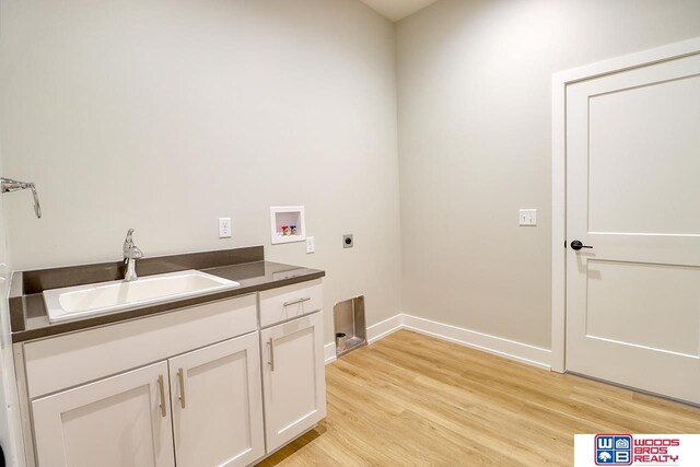 clothes washing area with cabinets, hookup for an electric dryer, light wood-type flooring, sink, and hookup for a washing machine