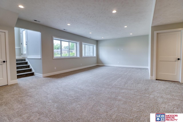 carpeted spare room with a textured ceiling