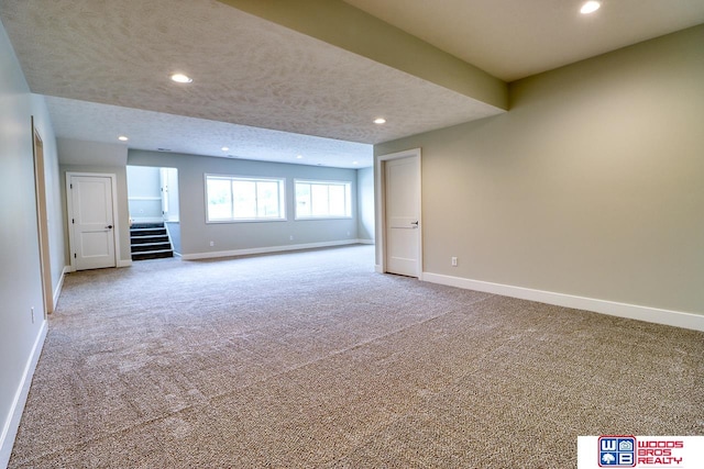 unfurnished living room featuring carpet floors and a textured ceiling