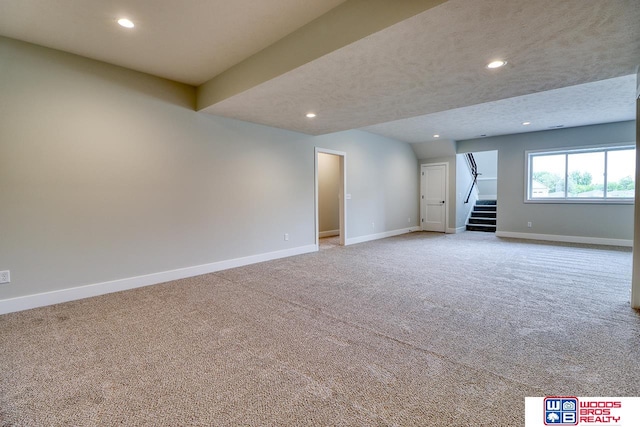 basement with light colored carpet and a textured ceiling