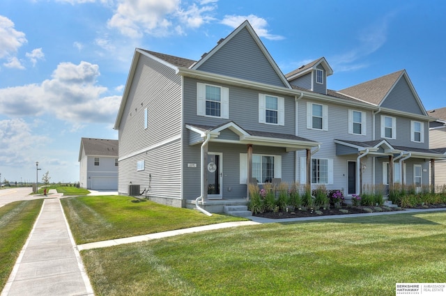 view of front of house with a front lawn, central AC unit, a porch, and a garage