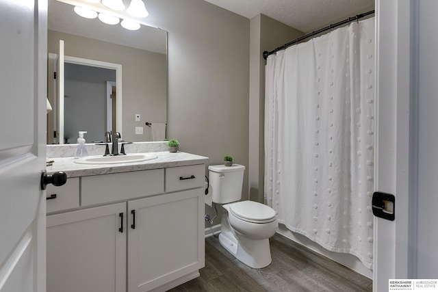 bathroom with curtained shower, vanity, a textured ceiling, hardwood / wood-style flooring, and toilet