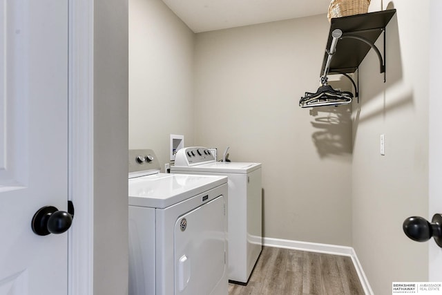 washroom with washer and clothes dryer and light hardwood / wood-style flooring