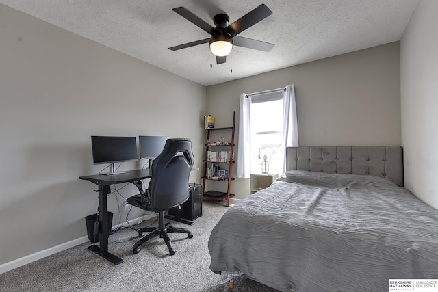 carpeted bedroom with ceiling fan and a textured ceiling