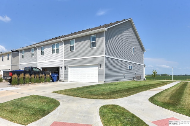 view of side of home featuring cooling unit, a yard, and a garage