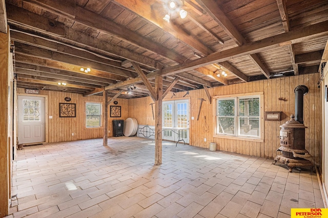 interior space featuring wood ceiling, wood walls, and a wood stove