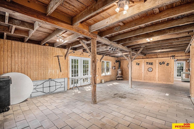 basement with wooden ceiling, wooden walls, and french doors