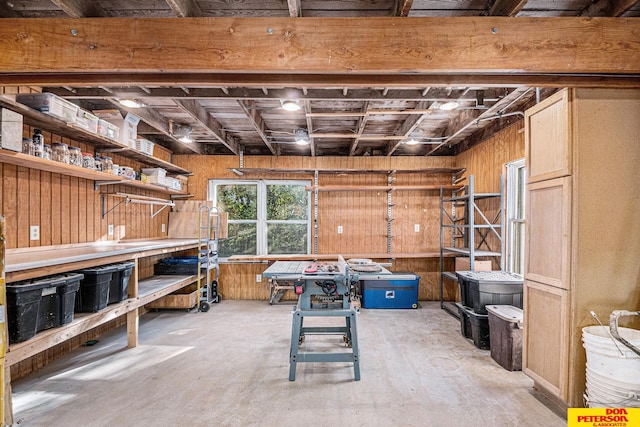 basement featuring wood walls and a workshop area