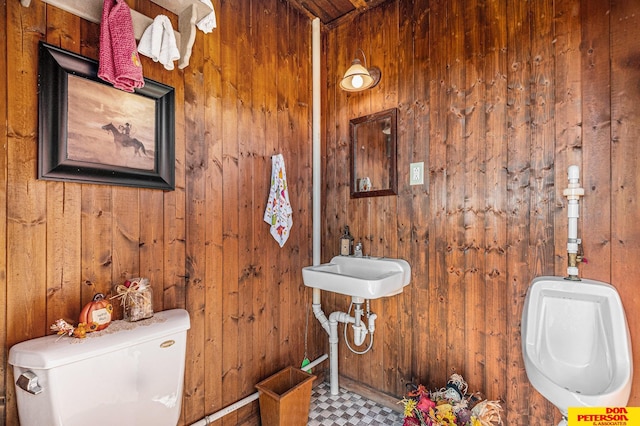 bathroom featuring wooden walls and toilet