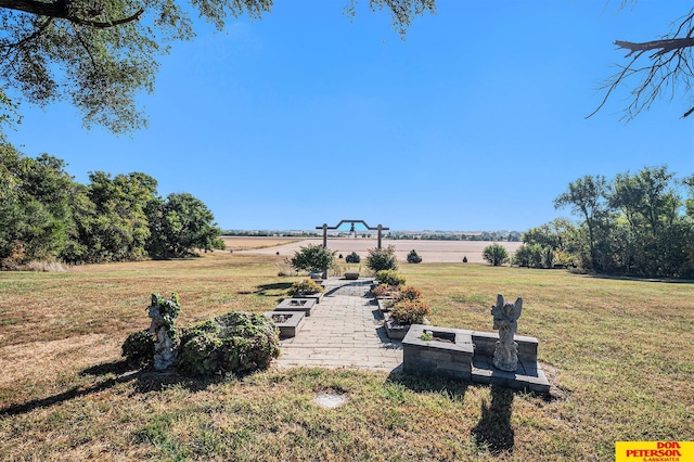 view of yard with an outdoor fire pit and a rural view