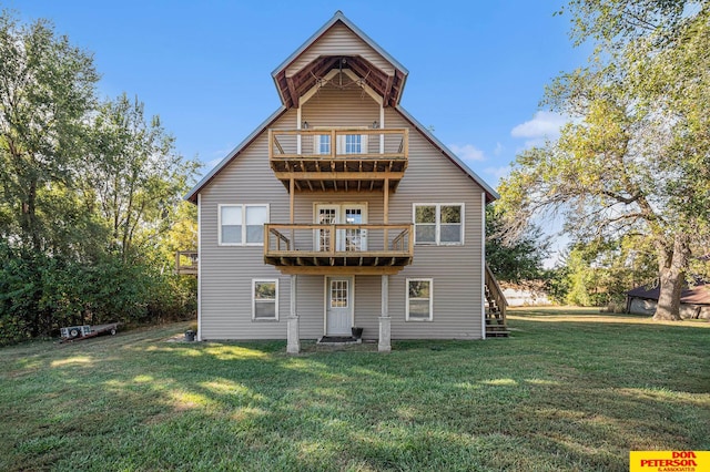 back of property featuring a balcony and a yard