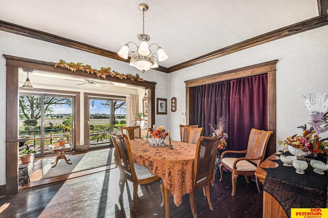 dining area with ceiling fan with notable chandelier, dark wood-type flooring, and crown molding